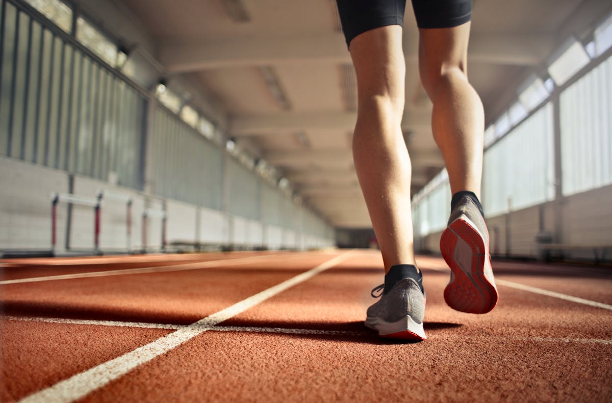 Runner training on a track in warm conditions